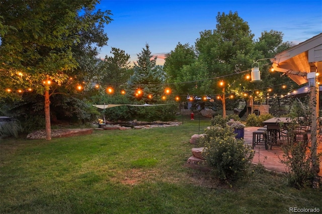 yard at dusk featuring a patio