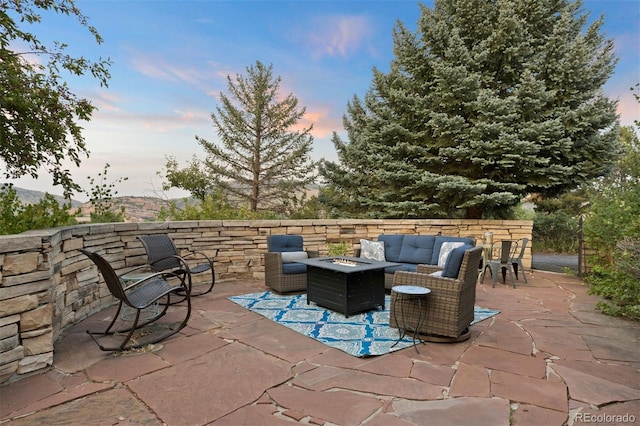 patio terrace at dusk with a mountain view and an outdoor living space with a fire pit