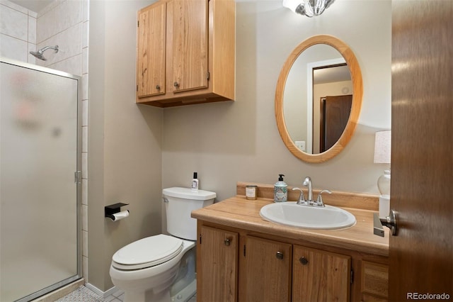 bathroom with vanity, a shower with shower door, and toilet