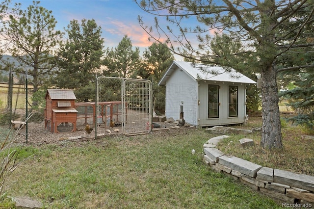 yard at dusk featuring an outdoor structure