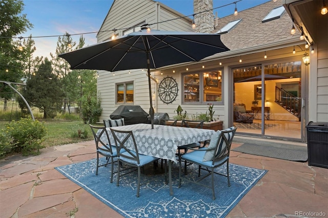 patio terrace at dusk featuring area for grilling