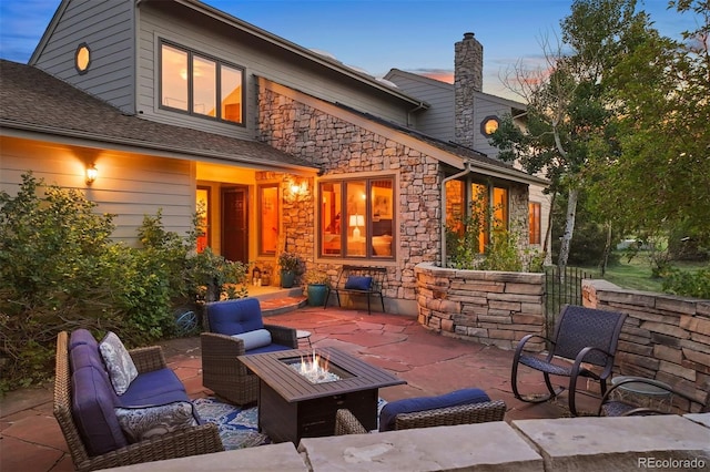 patio terrace at dusk featuring an outdoor living space with a fire pit