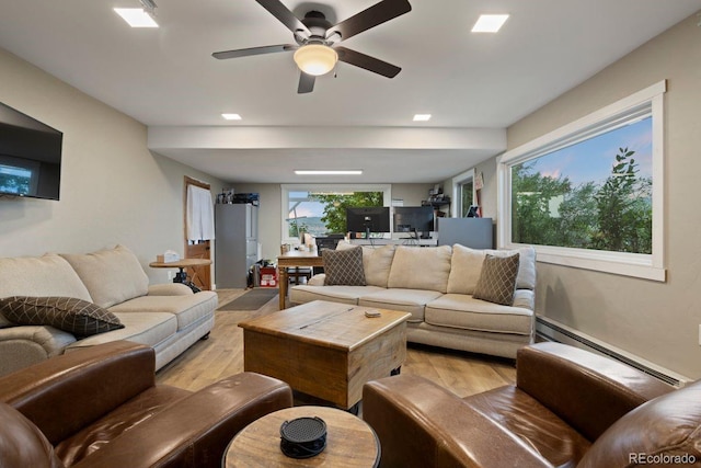 living room with ceiling fan, light hardwood / wood-style flooring, and a baseboard radiator