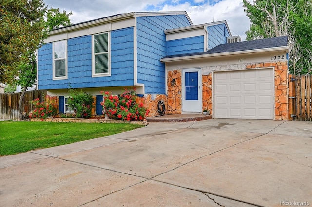 1922 Danube Way, Aurora, CO 80011 - split level home featuring driveway, an attached garage, and stone siding