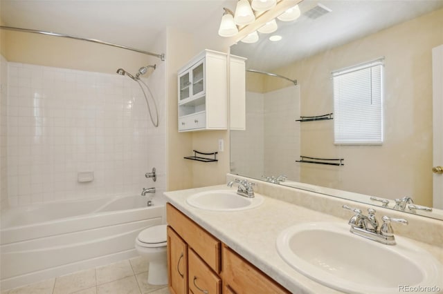 full bathroom with tile patterned flooring, tiled shower / bath combo, toilet, and vanity