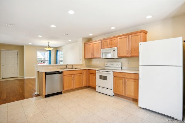 kitchen featuring kitchen peninsula, white appliances, sink, light hardwood / wood-style flooring, and hanging light fixtures