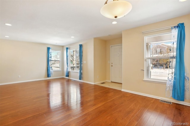 unfurnished room featuring hardwood / wood-style flooring and plenty of natural light