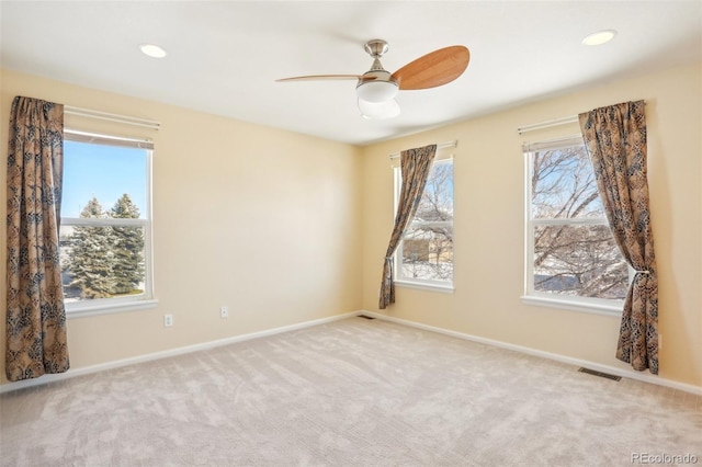 spare room featuring ceiling fan and light carpet