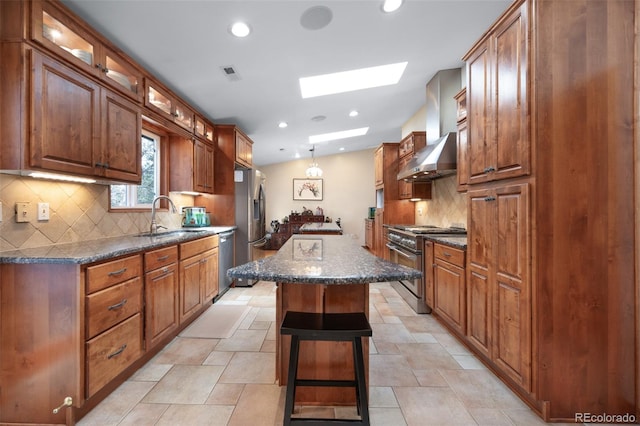 6535 Arequa Ridge Ln, Colorado Springs, CO 80919 - kitchen with wall chimney range hood, appliances with stainless steel finishes, a sink, a center island, and a skylight