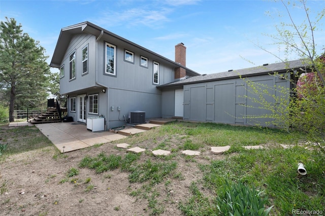 6535 Arequa Ridge Ln, Colorado Springs, CO 80919 - back of house with an outdoor structure, cooling unit, a patio, a shed, and a chimney