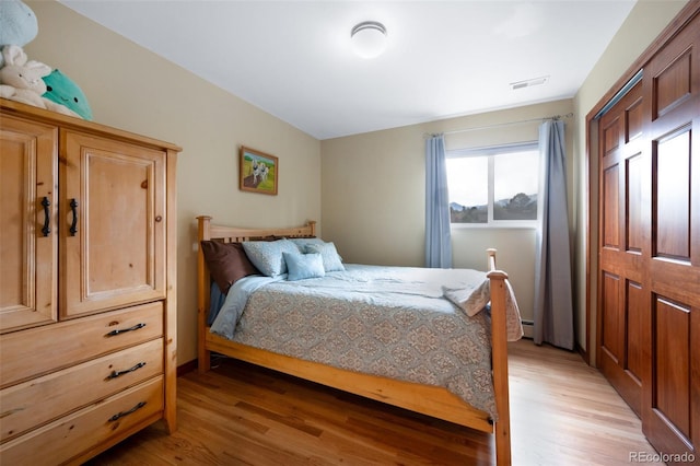 6535 Arequa Ridge Ln, Colorado Springs, CO 80919 - bedroom with visible vents, light wood-style flooring, and a baseboard heating unit