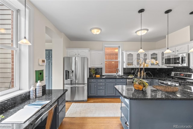 963 N Lafayette St, Denver, CO 80218 - kitchen with appliances with stainless steel finishes, white cabinetry, a sink, and backsplash