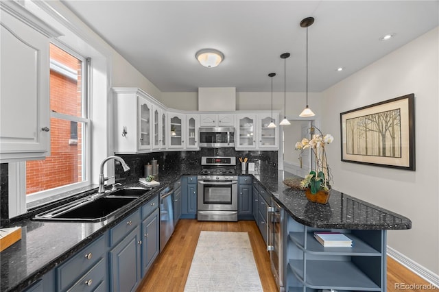 963 N Lafayette St, Denver, CO 80218 - kitchen featuring stainless steel appliances, open shelves, a peninsula, and white cabinetry
