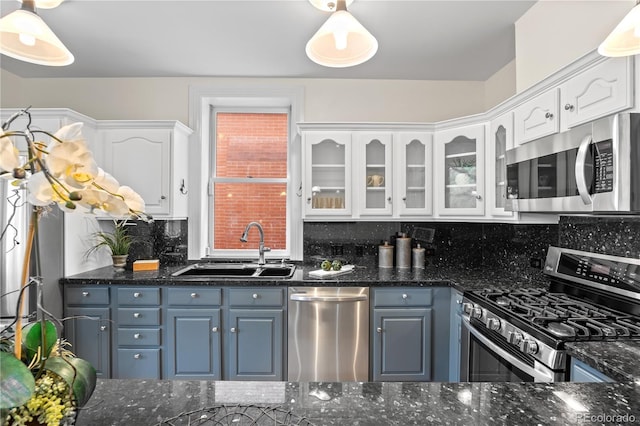 963 N Lafayette St, Denver, CO 80218 - kitchen featuring stainless steel appliances, a sink, white cabinets, tasteful backsplash, and glass insert cabinets