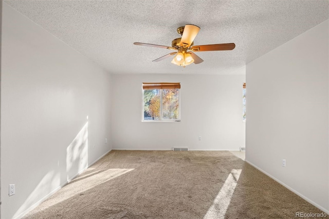 carpeted spare room featuring ceiling fan and a textured ceiling