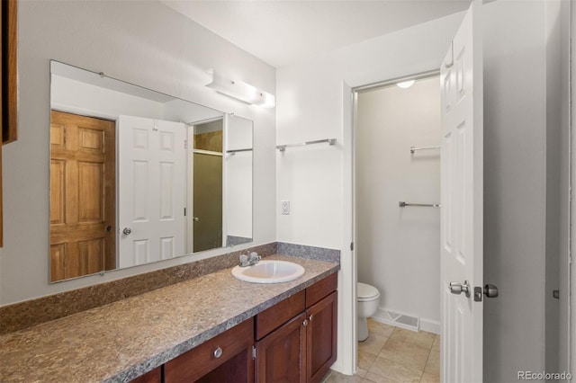 bathroom with tile patterned flooring, vanity, toilet, and a shower with door