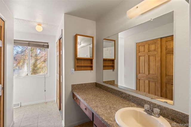 bathroom featuring tile patterned flooring, vanity, and a textured ceiling