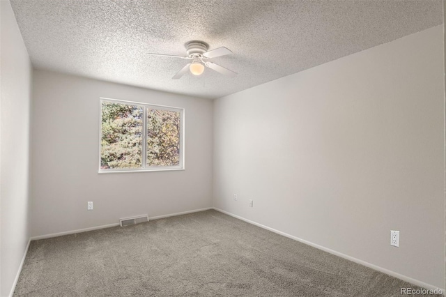 spare room featuring ceiling fan, carpet, and a textured ceiling