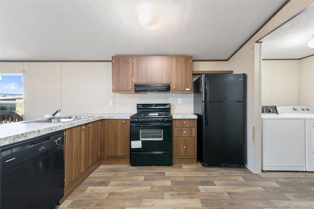 kitchen with washer and clothes dryer, sink, black appliances, hardwood / wood-style floors, and range hood