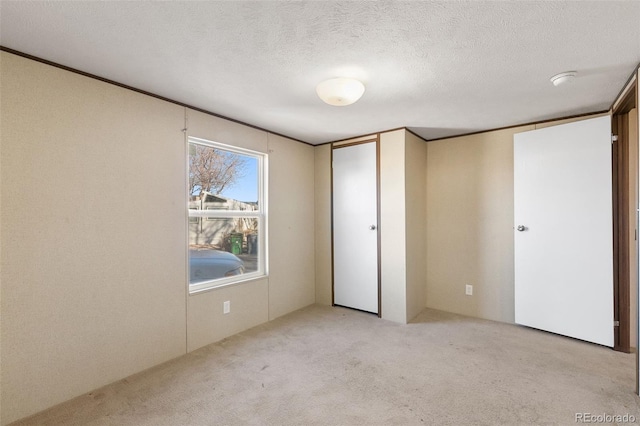 unfurnished bedroom featuring light carpet and a textured ceiling