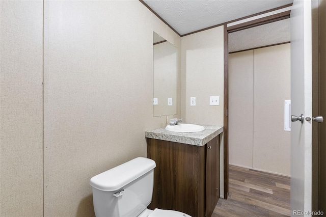 bathroom featuring toilet, vanity, a textured ceiling, and hardwood / wood-style flooring