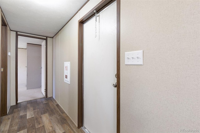 hallway featuring a textured ceiling and dark hardwood / wood-style floors