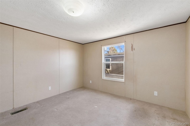 carpeted empty room with a textured ceiling