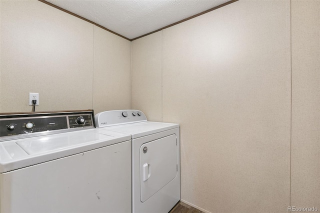 washroom featuring ornamental molding, a textured ceiling, and washing machine and clothes dryer