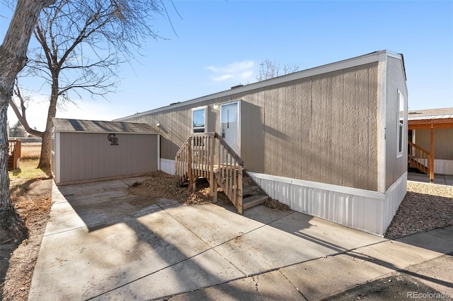 back of house featuring a patio area and an outbuilding