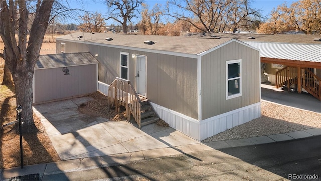 exterior space with a carport and a storage unit