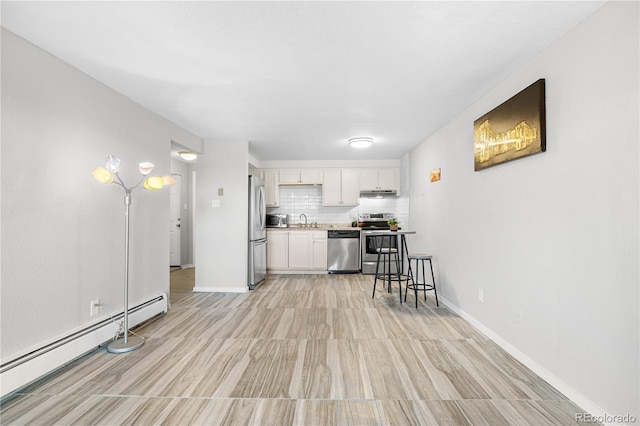 1304 S Parker Rd Unit 359, Denver, CO 80231 - kitchen with appliances with stainless steel finishes, a baseboard radiator, white cabinets, light countertops, and light wood-type flooring