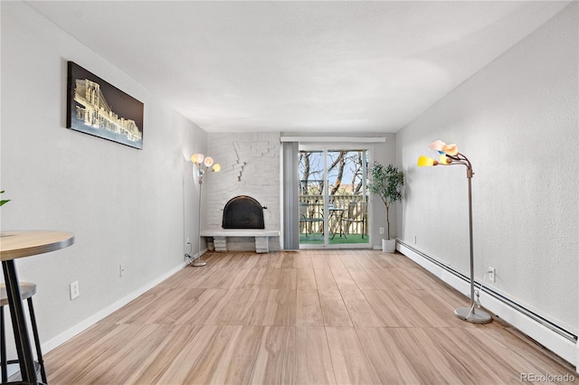 1304 S Parker Rd Unit 359, Denver, CO 80231 - unfurnished living room with baseboard heating, a stone fireplace, and wood finished floors