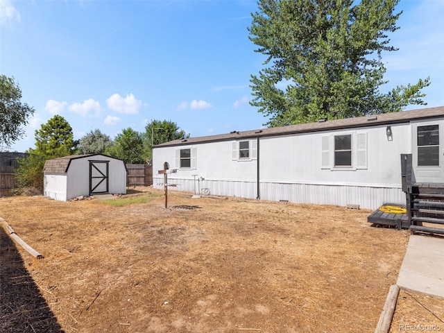 rear view of property featuring a storage unit