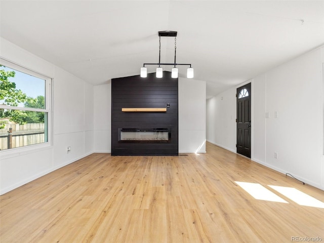 interior space with a large fireplace, light hardwood / wood-style flooring, and vaulted ceiling