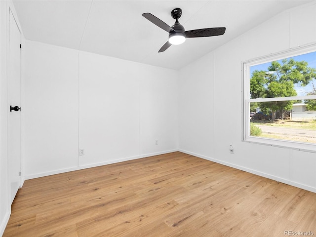 empty room with vaulted ceiling, ceiling fan, and light hardwood / wood-style flooring