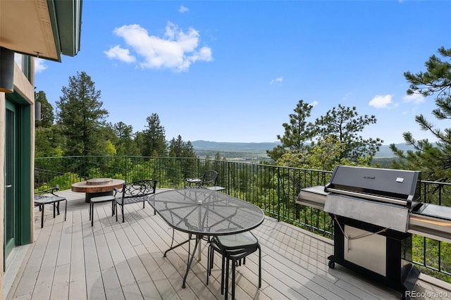 857 Pawnee Trl, Castle Rock, CO 80108 - wooden deck with a fire pit, a mountain view, a grill, and outdoor dining area
