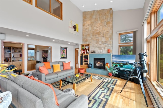857 Pawnee Trl, Castle Rock, CO 80108 - living room with wood finished floors, a towering ceiling, recessed lighting, a stone fireplace, and a baseboard heating unit