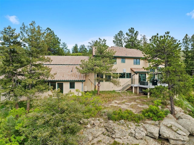 857 Pawnee Trl, Castle Rock, CO 80108 - back of property with a tiled roof, stairway, stucco siding, and a deck