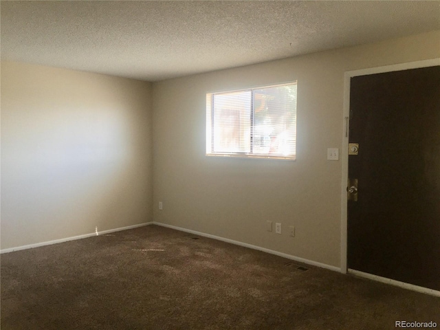 carpeted spare room with a textured ceiling