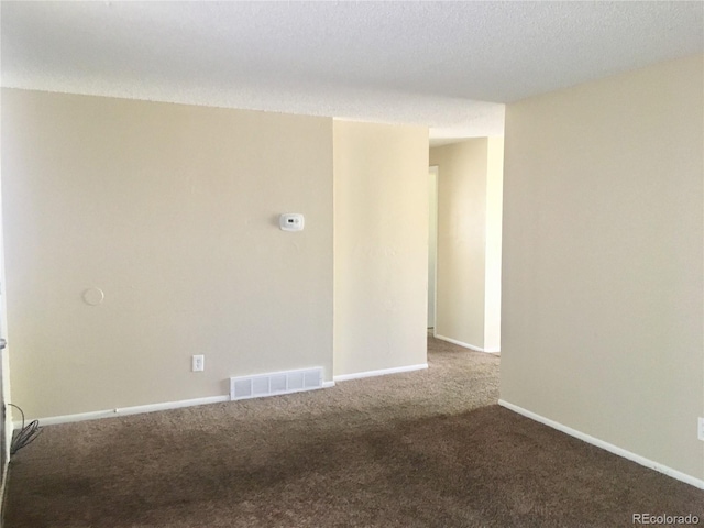 spare room featuring carpet and a textured ceiling