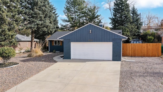 garage featuring driveway and fence