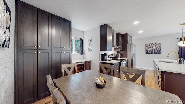 dining room featuring light wood finished floors, recessed lighting, beverage cooler, and baseboards