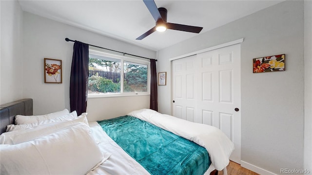 bedroom with a closet, baseboards, ceiling fan, and wood finished floors