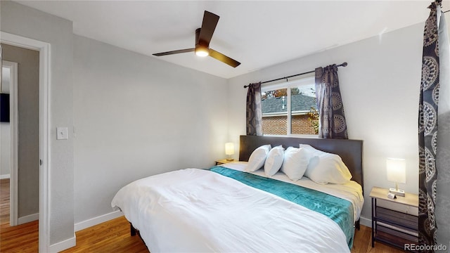 bedroom featuring a ceiling fan, wood finished floors, and baseboards