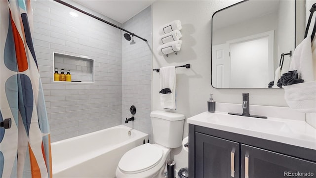 full bathroom featuring vanity, shower / bath combination with curtain, and toilet