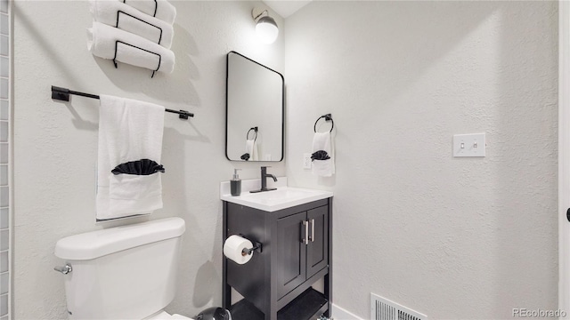 bathroom with visible vents, toilet, and vanity