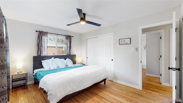 bedroom with a ceiling fan, light wood-style floors, baseboards, and a closet