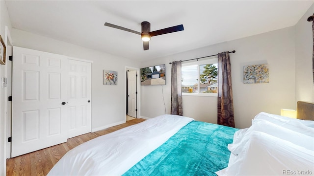 bedroom with baseboards, a ceiling fan, and light wood-style floors