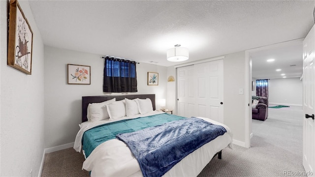 carpeted bedroom with a closet, baseboards, and a textured ceiling