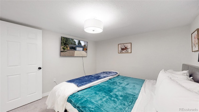 bedroom with carpet flooring, a textured ceiling, and baseboards